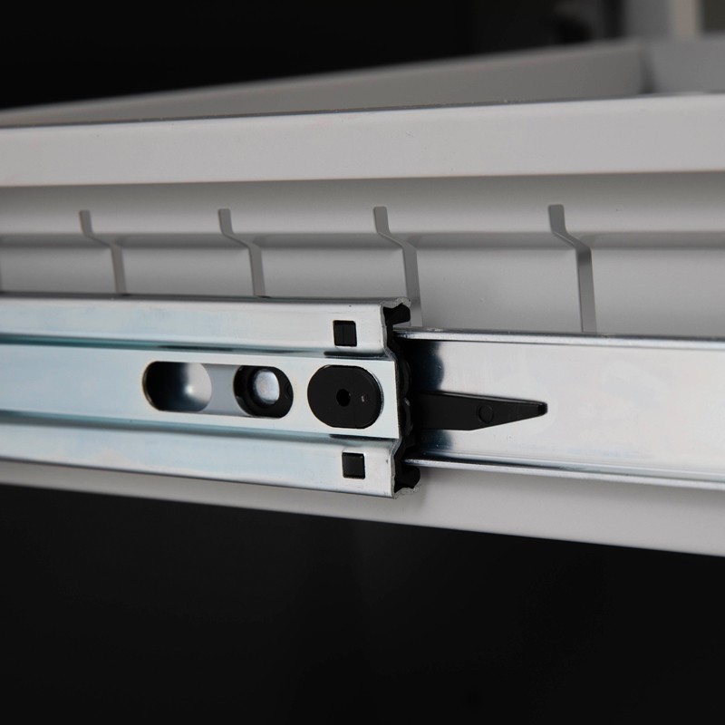 Zoom en los rieles telescópicos de un cajón del escritorio metálico doble