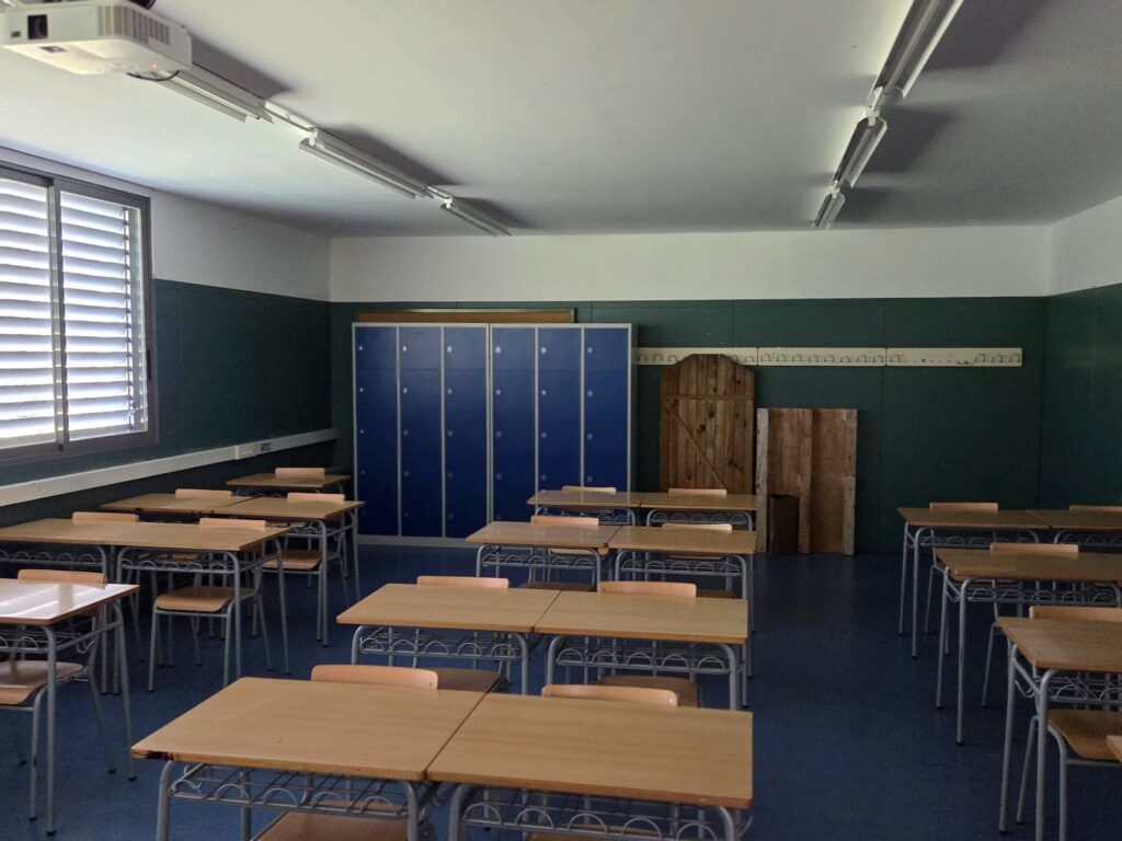 Taquillas escolares azules integradas en un aula con mesas y sillas de alumnos